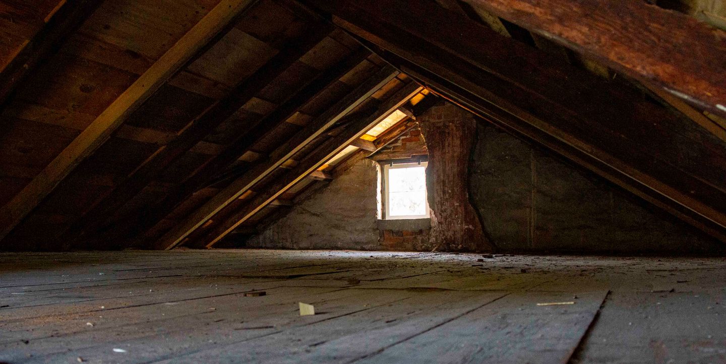 Unfinished attic framing and brick wall in an illustrative historic building interior